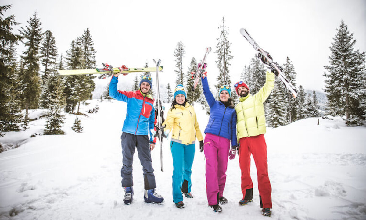 skupina lyžiarov na kopci pózuje pre fotografiu