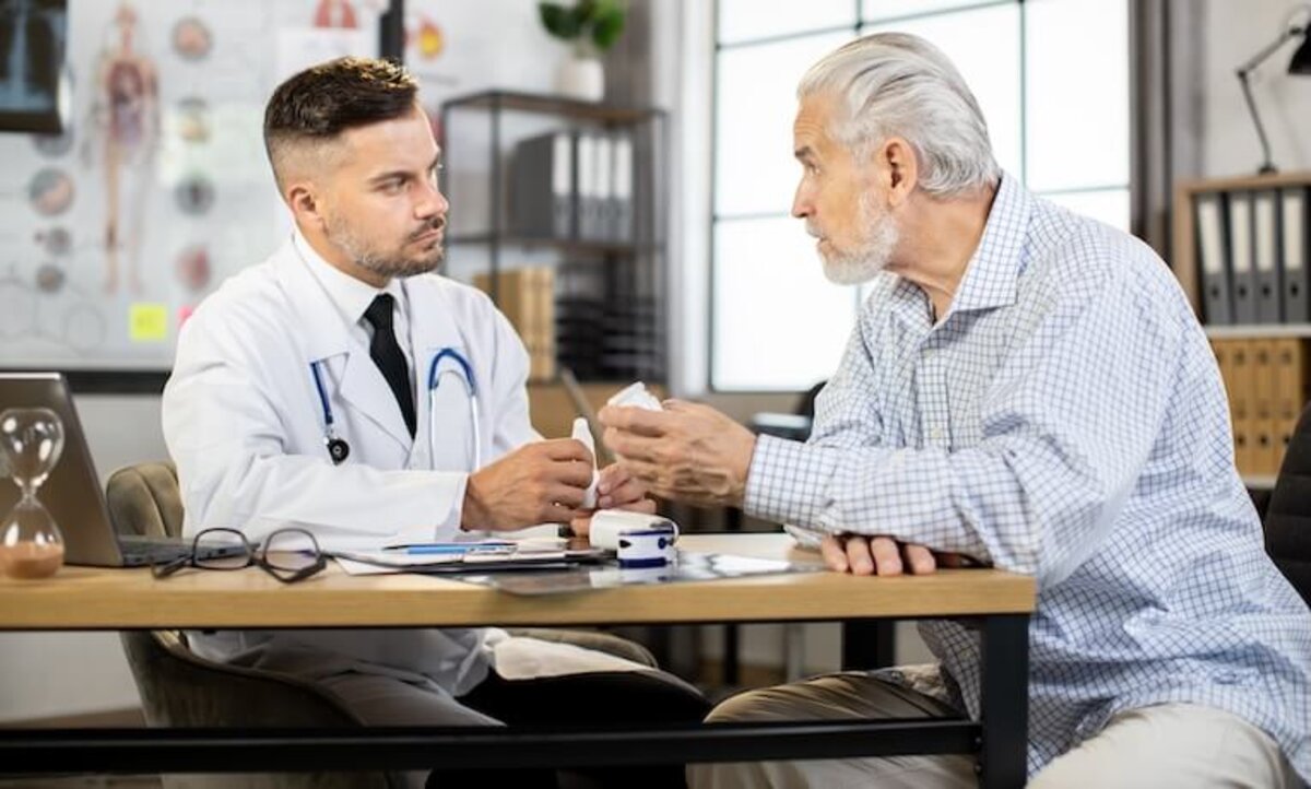 starší muž diskutujúci s lekárom