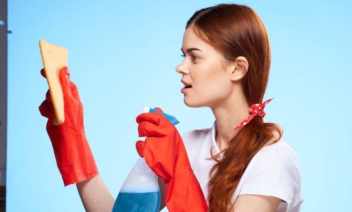 žena v gumených rukaviciach s čistiacim prostriedkom