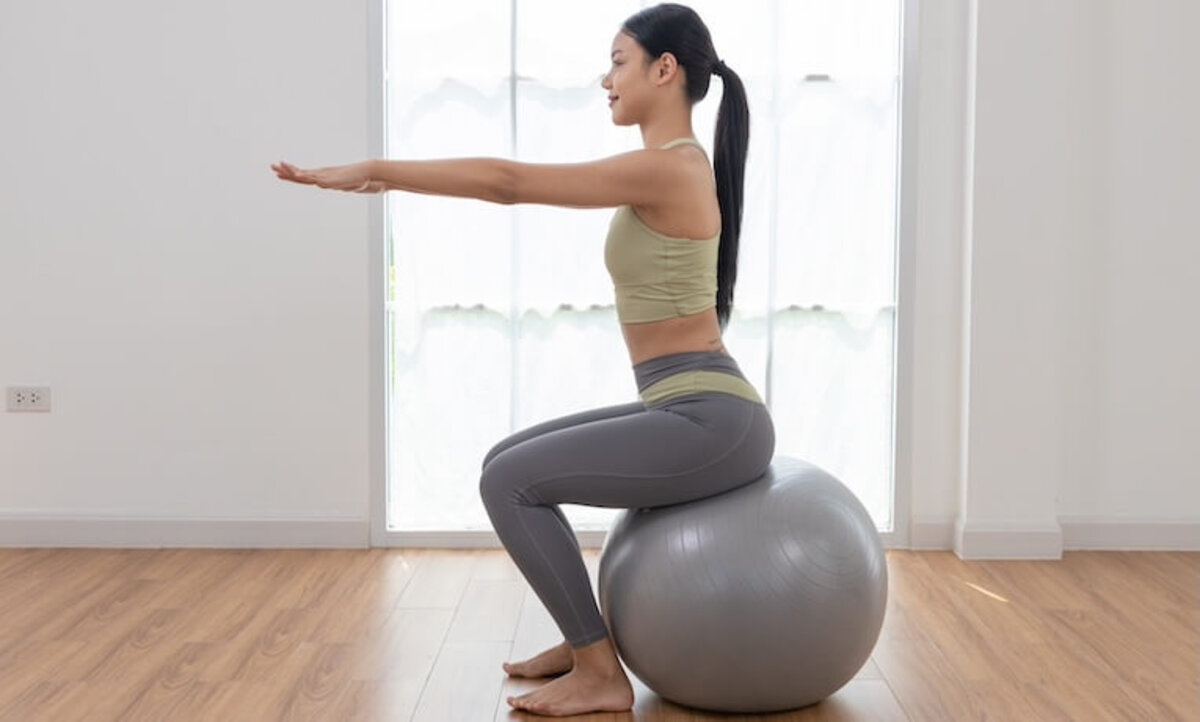 mladá žena cvičí na gymnastickej lopte