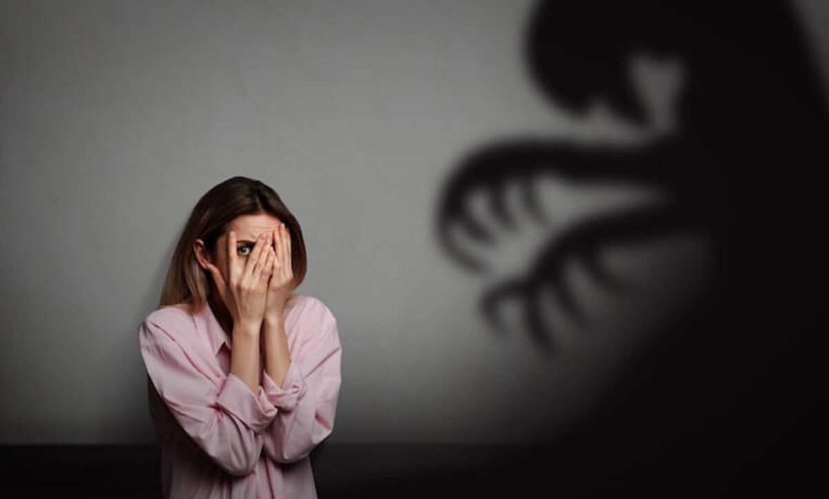 žena si zakýva oči pred strašidelným tieňom