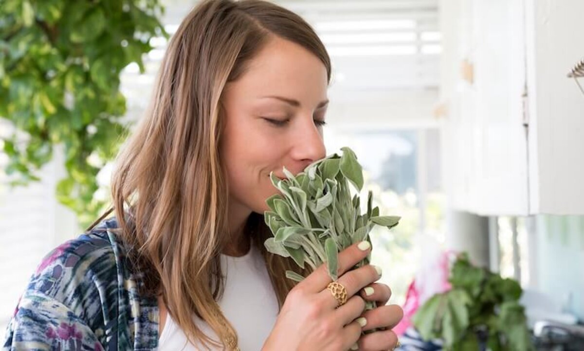 žena privoniava k bylinkám