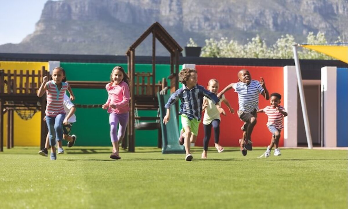 skupina bežiacich detí na detskom ihrisku