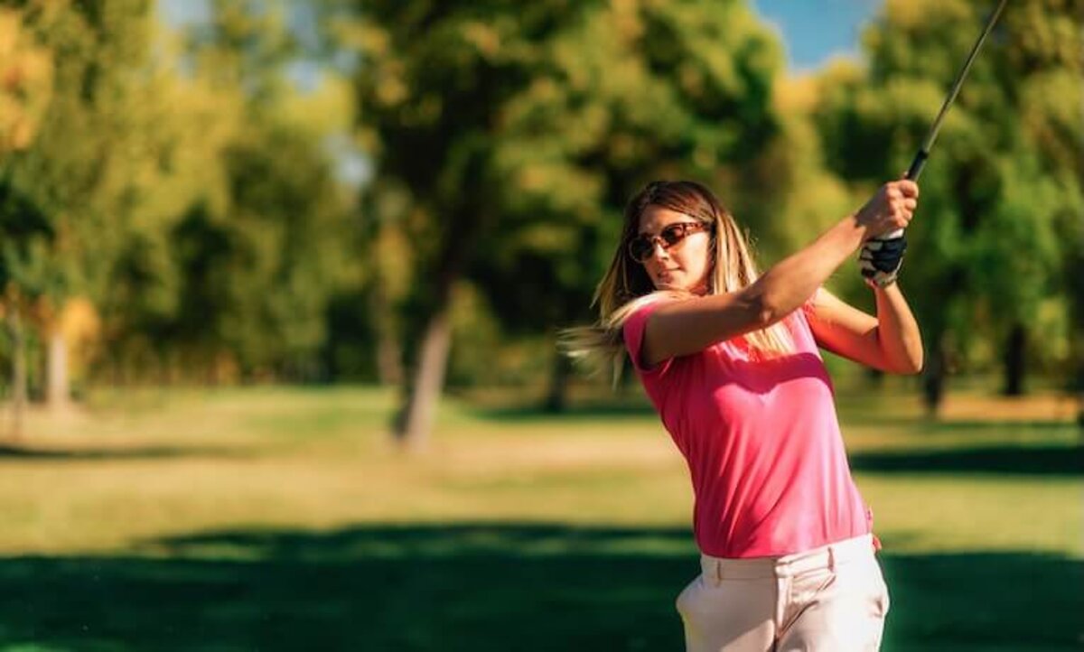 mladá žena hrá golf počas slnečného dňa