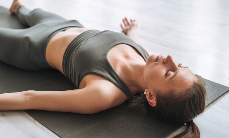 žena ležiaca na karimatke v uvoľnenej pozícii na chrbte