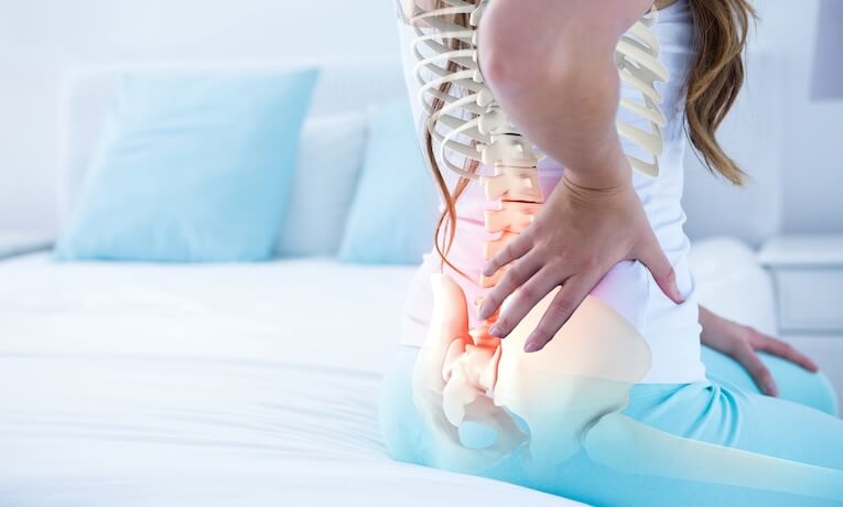 detail sediacej ženy s vyznačenou chrbticou, rebrami, panvou s stehennou kosťou