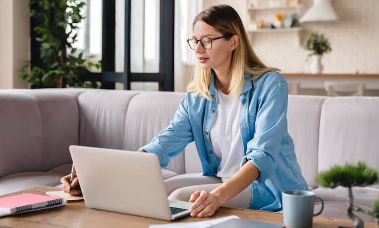 žena pracujúca na notebooku doma na sedačke