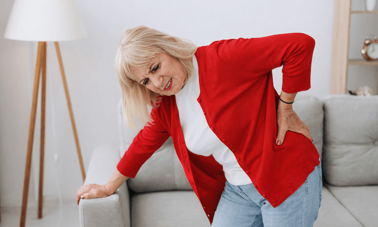 staršia žena v predklone so silnou bolesťou v krížoch