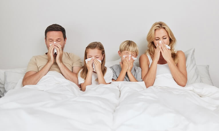 štvorčlenná rodina s nádchou v posteli