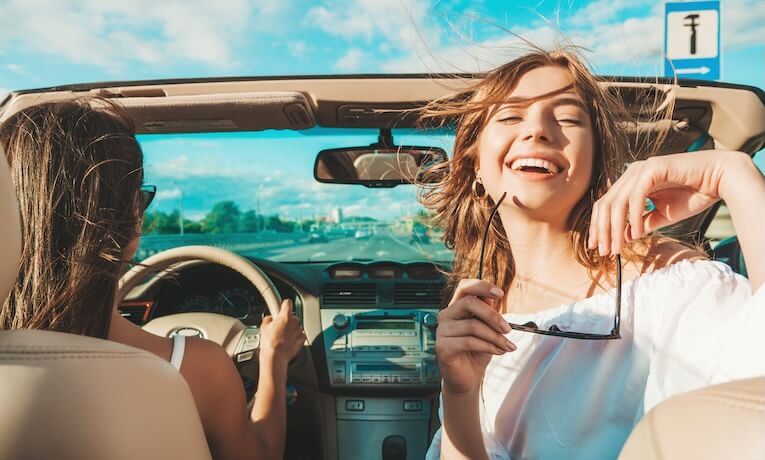 dve mladé ženy idúce v kabriolete