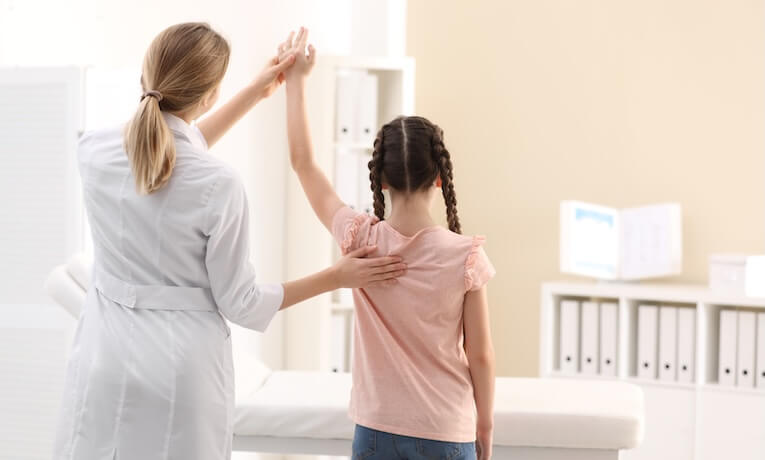 doktorka vyšetruje chrbát dieťaťa