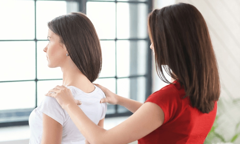 jedna žena narovnáva chrbát druhej žene