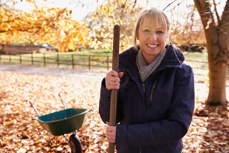 žena v záhrade s popadaným lístím