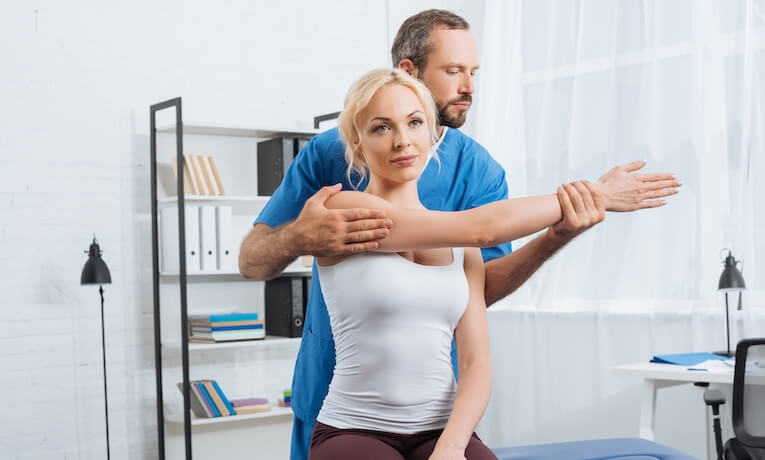 fyzioterapeut cvičí s mladou ženou