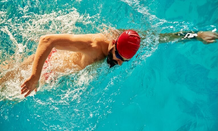 muž v bazéne pláva kraul