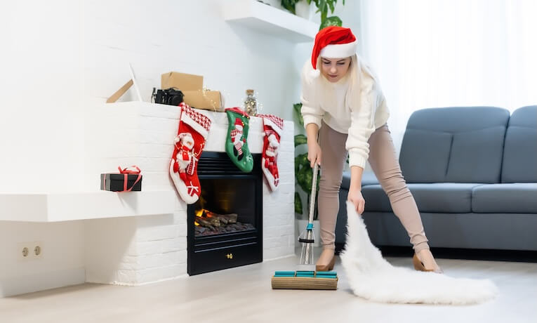 žena s mikulášskou čiapkou umýva podlahy