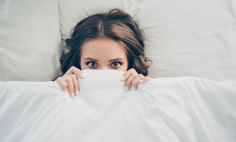 žena sa zakrýva paplónom až po oči